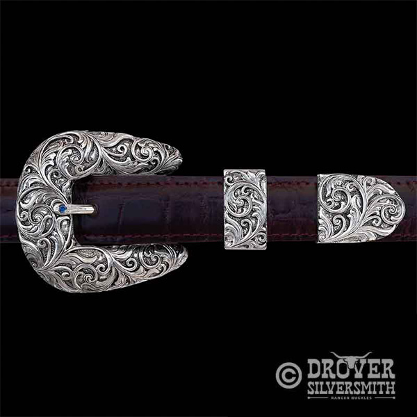 Introducing The Cowpoke Sterling Silver Belt Buckle, a durable hand engraved buckle set detailed with a classy antiqued finish and a refined touch of color. Add a second loop for a ranger buckle set now!